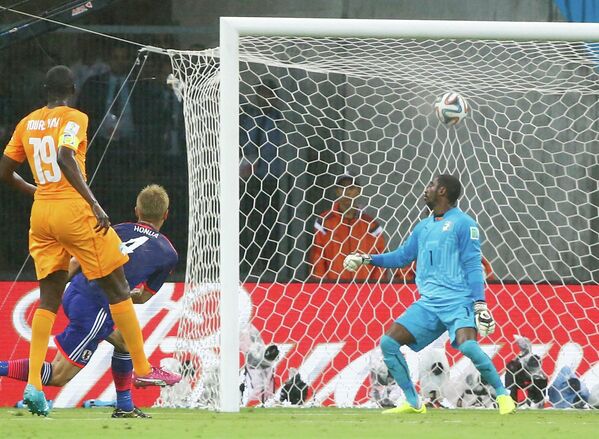 Полузащитник сборной Японии Кейсуке Хонда забивает гол в ворота ивуарийцев.