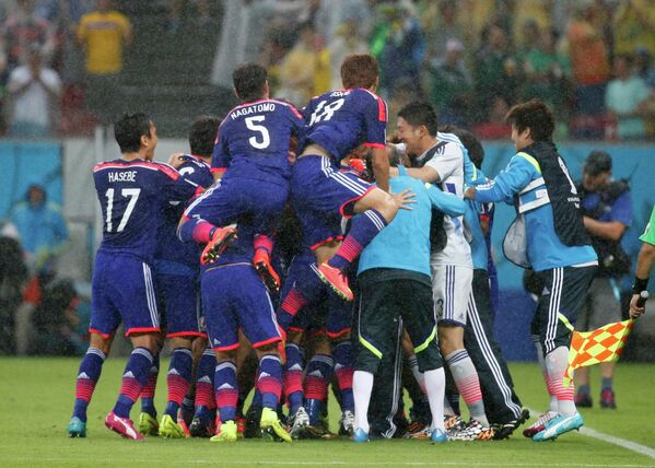 Футболисты сборной Японии празднуют гол.