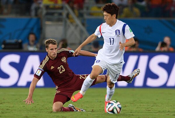 На фото: защитник сборной России Дмитрий Комбаров и полузащитник сборной Южной Кореи Ли Чхун Ен (слева направо).