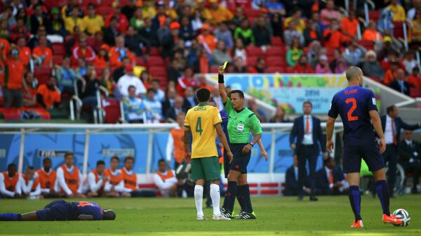Полузащитник сборной Австралии Тим Кэхилл (в центре) получается желтую карточку за фол на Мартинсе Инди