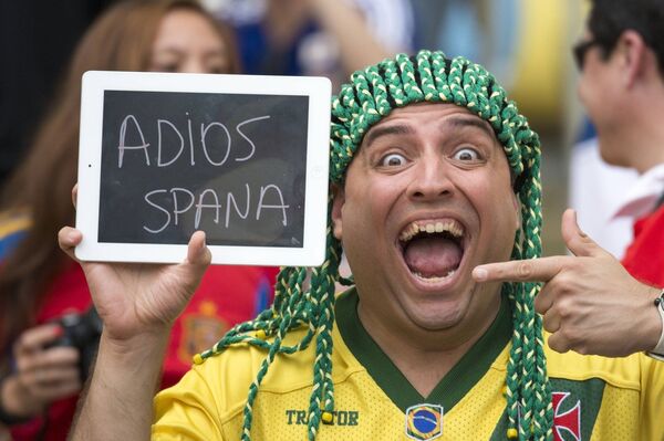 Болельщики сборной Бразилии держит табличку с надписью До свидания, Испания