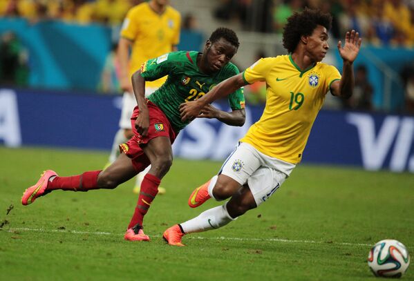 Полузащитник сборной Камеруна Эдгар Салли и полузащитник сборной Бразилии Виллиан (справа).