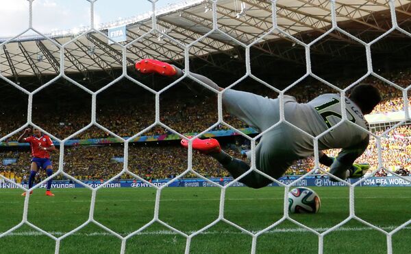 Голкипер сборной Бразилии Жулио Сезар отбивает удар нападающего сборной Чили Алексиса Санчеса