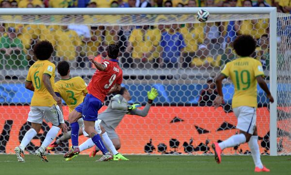 Нападающий сборной Чили Маурисио Пинилья наносит удар в перекладину ворот бразильцев