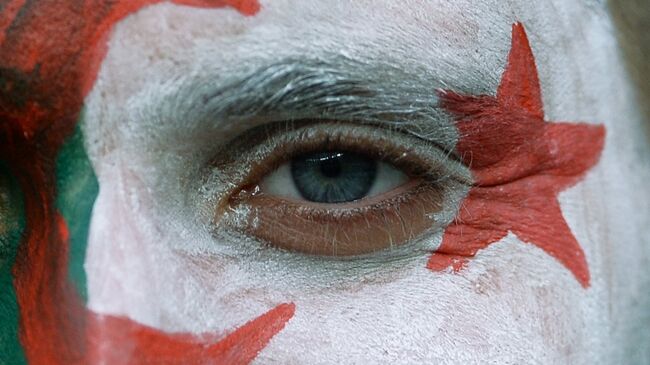 Человек с нарисованным на лице флагом Алжира