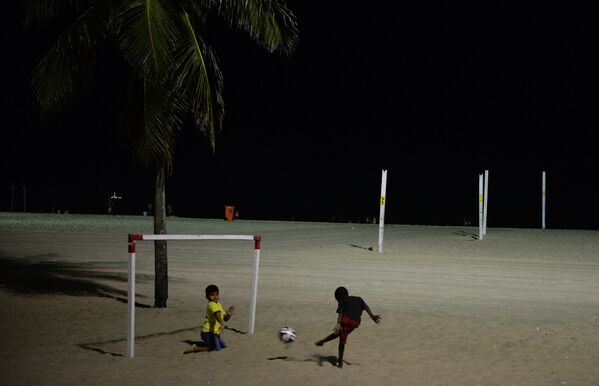 Дети играют в футбол на бразильском пляже