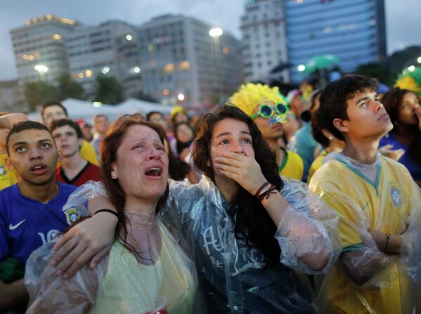 Болельщики сборной Бразилии плачут, наблюдая за игрой своей команды.
