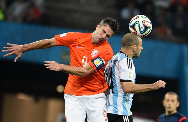 Нападающий сборной Нидерландов Робин ван Перси и полузащитник сборной Аргентины Хавьер Маскерано (справа) в полуфинальном матче чемпионата мира по футболу.
