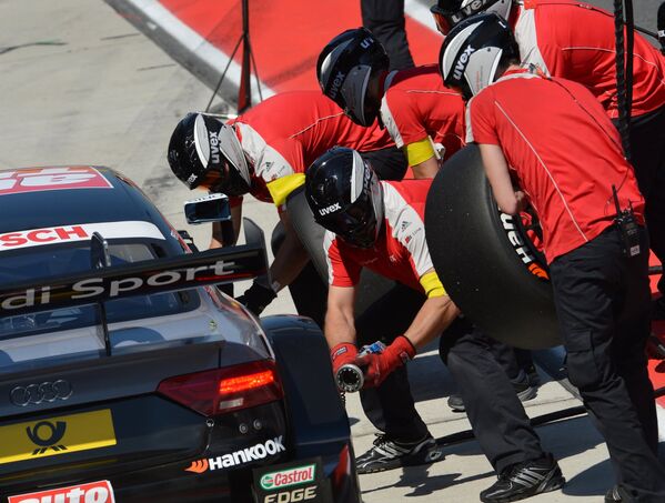 Бригада механиков команды Audi Sport Team Phoenix на пит-лейне у автомобиля пилота Тимо Шайдера