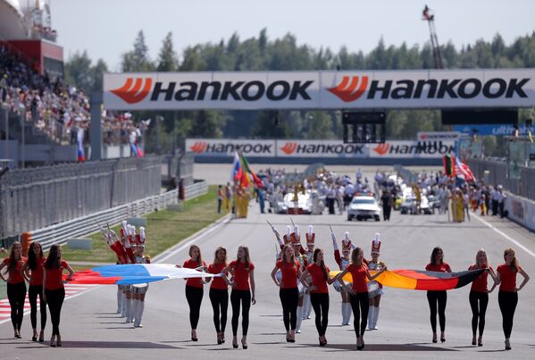 Девушки несут флаг России и Германии перед началом стартом гонки в третий день пятого этапа немецкого чемпионата по кузовным гонкам (DTM)