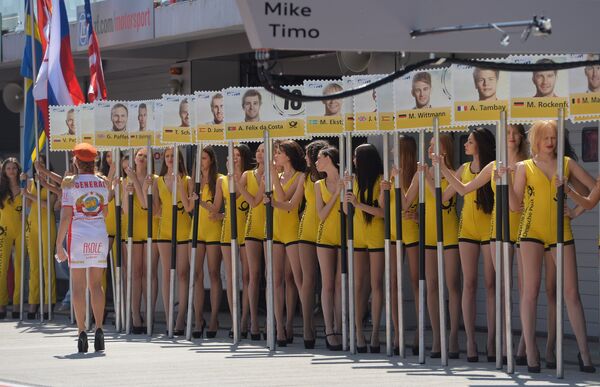 Девушки во время церемонии представления гонщиков перед началом гонки пятого этапа немецкого чемпионата по кузовным гонкам (DTM)