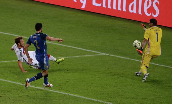 Форвард сборной Германии Марио Гетце (слева на втором плане) забивает гол в ворота Серхио Ромеро (справа)