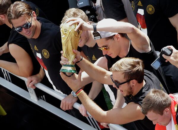 Футболисты сборной Германии показывают кубок поклонникам футбола