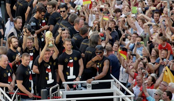 Футболисты сборной Германии показывают кубок поклонникам футбола