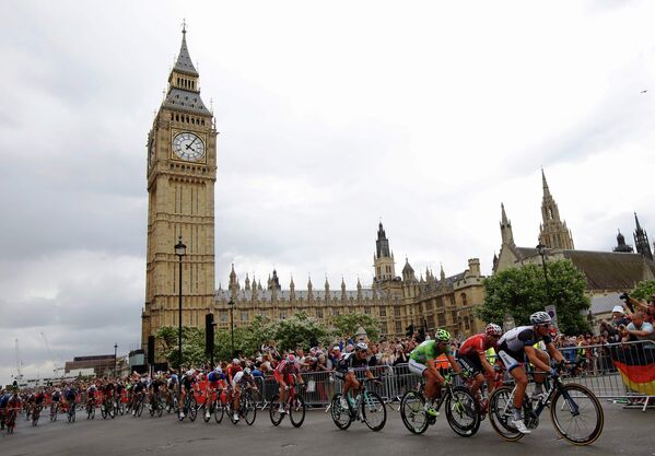 Группа велогонщиков на третьем этапе Тур де Франс проезжает всемирно известную достопримечательность - часы Биг Бен в Лондоне