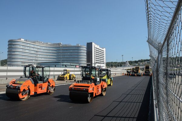 Рабочие укладывают асфальт на строительстве трассы гоночного комплекса Сочи Автодром в Олимпийском парке