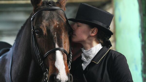 Наездница целует лошадь