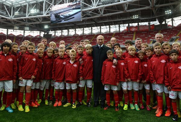 Президент России Владимир Путин (в центре) с юными футбалистами во время посещения стадиона Открытие Арена - домашнего стадион футбольного клуба Спартак (Москва) в Тушино