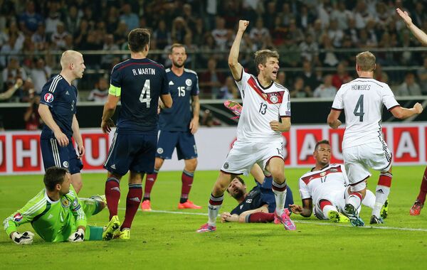 Нападающий сборной Германии Томас Мюллер (в центре) в матче против шотландских футболистов