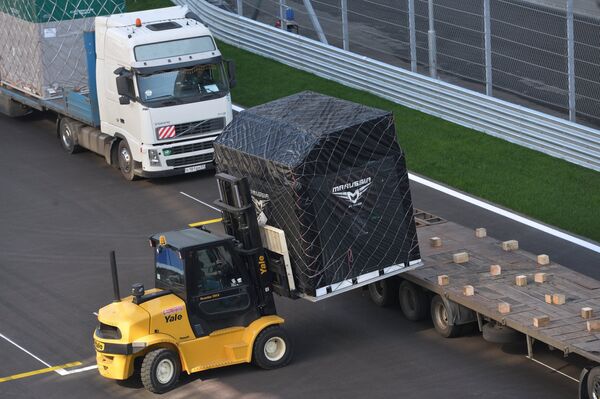 Разгрузка автомобиля с технологическим оборудованием команды Marussia на территории гоночной трассы Сочи Автодром