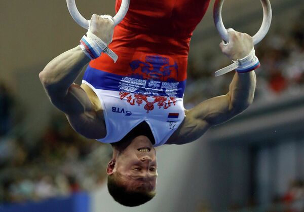 Денис Аблязин выступает в упражнении на кольцах на чемпионате мира по спортивной гимнастике