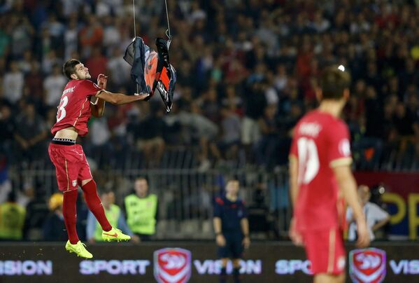 Защитник сборной Сербии Стефан Митрович ловит албанский флаг