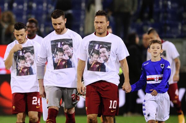 Футболисты Ромы в футболках с изображением двух болельщиков команды - отца и сына, которые погибли в автокатастрофе, возвращаясь с матча Лиги чемпионов против мюнхенской Баварии