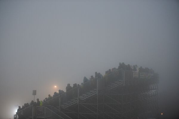 Зрители на трибуне в тумане.