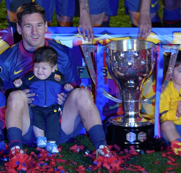 Лионель Месси со своим сыном Тьяго после завоеванием титула чемпиона Испании по итогам сезона 2012/2013, май 2013 года