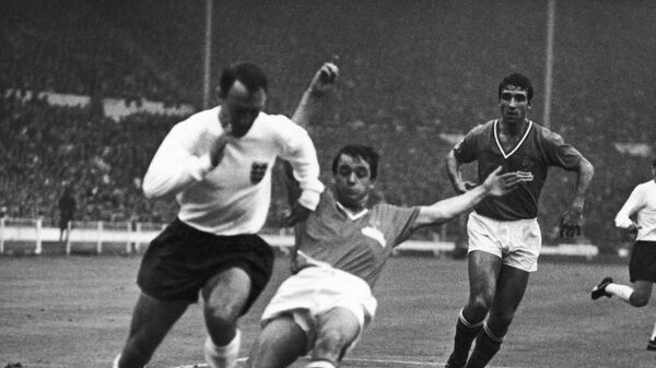 Нападающий сборной Англии по футболу Джимми Гривз (слева) в матче чемпионата мира-1966 с командой Франции