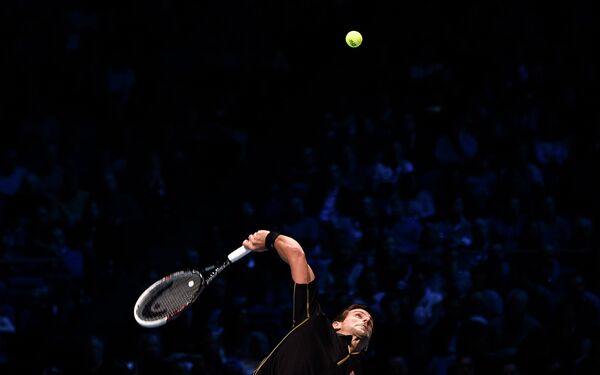 Новак Джокович совершает подачу в полуфинальном матче итогового теннисного турнира ATP
