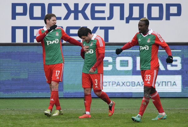 Футболисты Локомотива Тарас Михалик, Алан Касаев и Даме Н'Дойе (слева направо) радуются забитому голу.