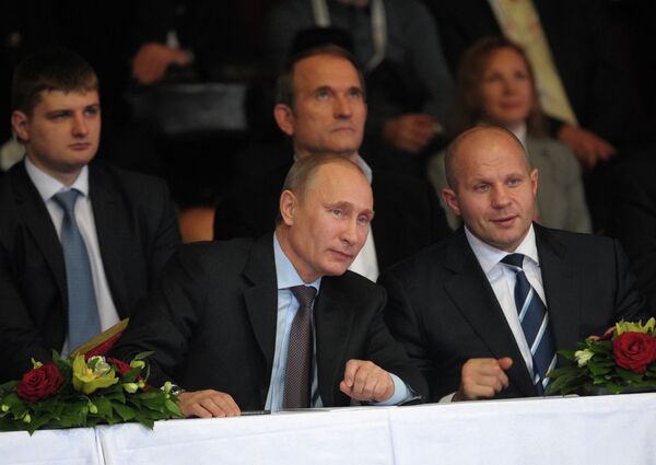 Президент России Владимир Путин (слева на первом плане) и многократный чемпион мира по боям без правил и боевому самбо Федор Емельяненко