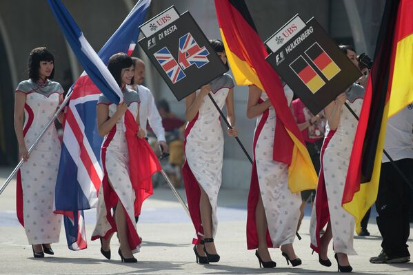 Девушки выносят таблички с именами гонщиков и флаги перед стартом Гран-при Китая Формулы-1