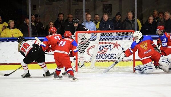 Канадская хоккеистка Сара Потомак бросает по воротам голкипера молодежной сборной России Алсу Рахимовой (вторая справа)