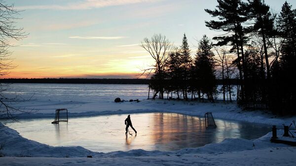 Юный спортсмен играет в хоккей на рассвете в Онтарио
