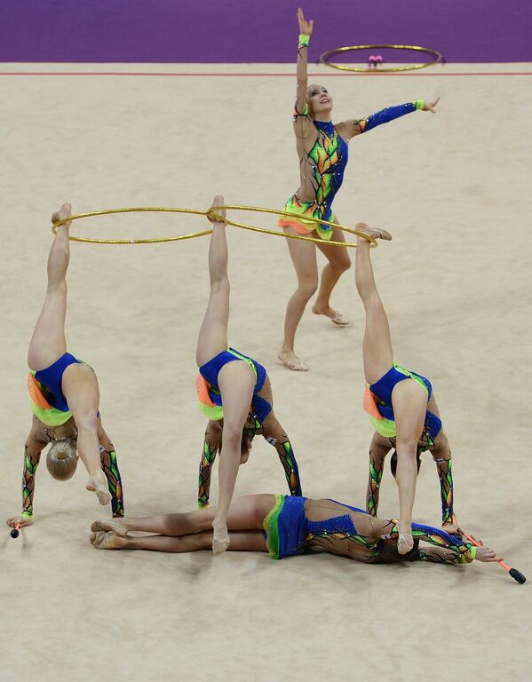 Гимнастки сборной Финляндии выполняют групповые упражнения с шестью булавами и двумя обручами
