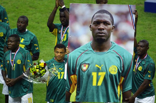 Футболисты сборной Камеруна держат плакат с изображением Марка Вивьена Фоэ