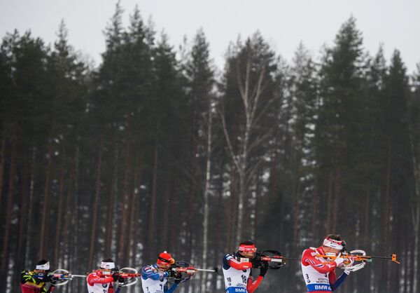 Биатлонисты Мартен Фуркад (Франция), Тарьей Бё (Норвегия), Антон Шипулин (Россия) (слева направо) на огневом рубеже гонки. преследования
