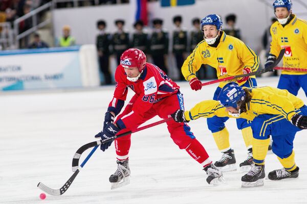 Форвард сборной России по хоккею с мячом Евгений Иванушкин (слева) в окружении шведских бендистов