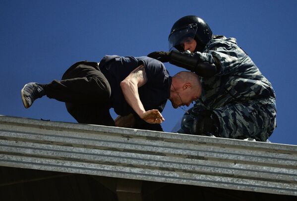 Сотрудник правоохранительных органов (справа) и болельщик на крыше стадиона