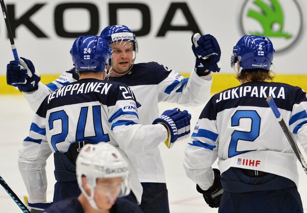 Хоккеисты сборной Финляндии Йоонас Кемппайнен, Ансси Салмела и Юрки Йокипакка (слева направо) радуются заброшенной шайбе
