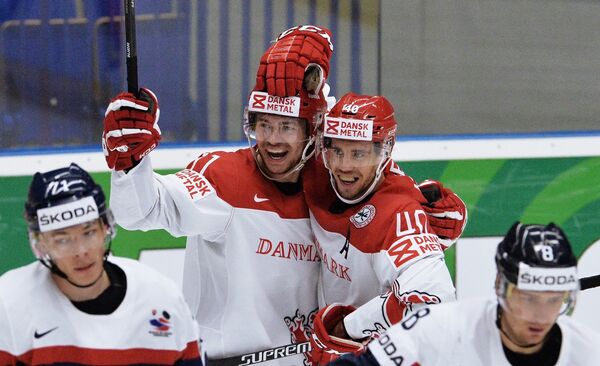 Хоккеисты сборной Дании Патрик Бьёркстранд и Йеспер Йенсен (в центре слева направо) радуются заброшенной шайбе