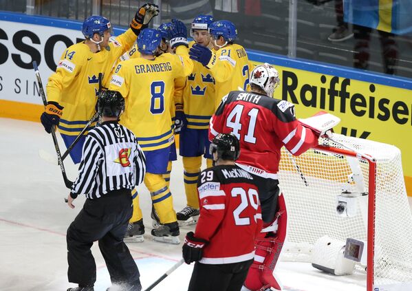 Хоккеисты сборной Швеции (слева) и сборной Канады Натан Маккиннон и Майк Смит
