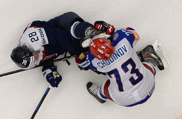 Игрок сборной России Максим Чудинов (справа) получает травму в матче группового раунда чемпионата мира по хоккею 2015 между сборными командами России и Словакии. Слева игрок сборной Словакии Рихард Паник.