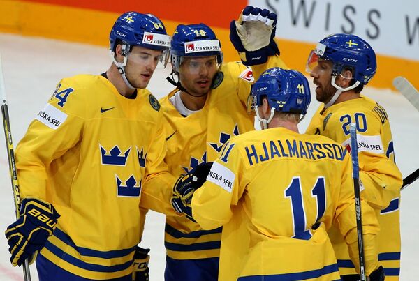 Хоккеисты сборной Швеции радуются голу