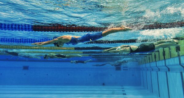 Спортсменки на дистанции во время соревнований по плаванию
