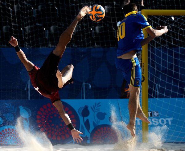 Игрок сборной Португалии Бруно Торрес и игрок сборной Украины Дмитрий Медведь (справа) в матче по пляжному футболу
