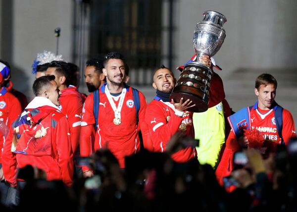 Полузащитник сборной Чили Артуро Видаль держит трофей за победу на Кубке Америки