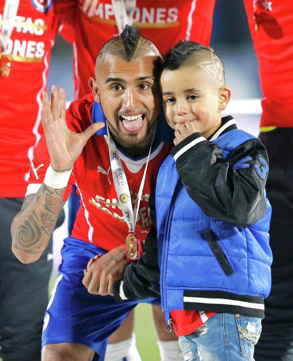 Полузащитник сборной Чили Артуро Видаль со своим сыном Алонсо после победы на Кубке Америки